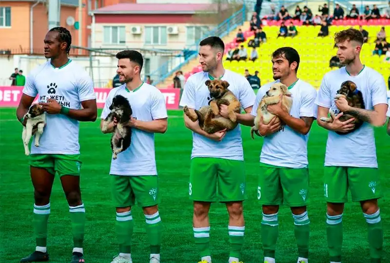 Atyraýlyq fýtbolshylar alańǵa bir-bir kúshik qushaqtap shyqty