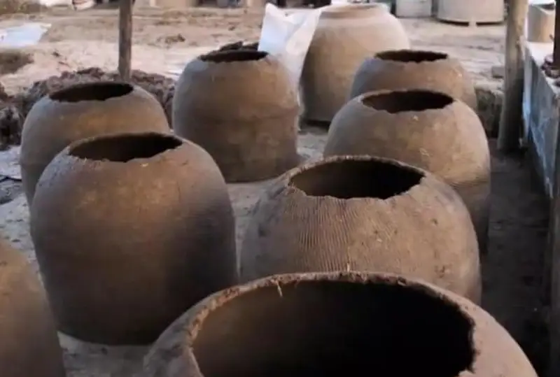 Туркистонлик эр-хотин лойдан тандир ясаш билан шуғулланади