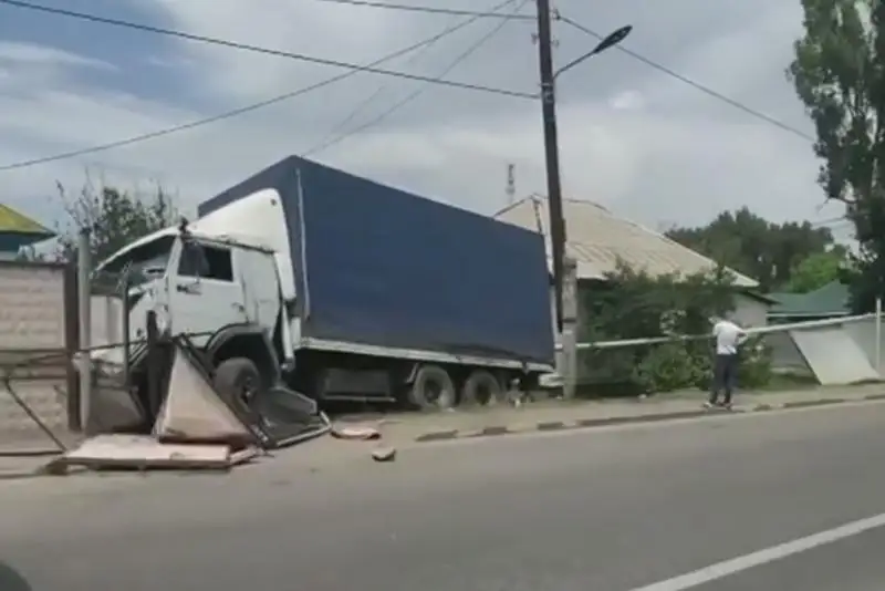 КамАЗ столкнулся с легковушкой и снес заборы в Алматы