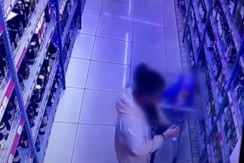 Qolyna sábı ustaǵan áıeldiń qymbat ishimdik urlaǵany vıdeoǵa túsip qaldy