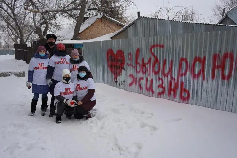 Волонтеры помогают полицейским закрашивать рекламу наркотиков на стенах домов в Костанае