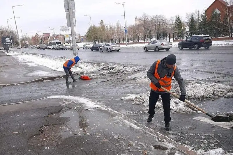 Júzdegen adam Nur-Sultan kóshelerin qardan tazartýda