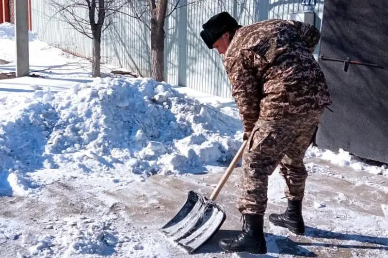 Atyraýda áskerıler maıdangerlerdiń úıine baryp, aýlasyndaǵy qardy kúrep berdi