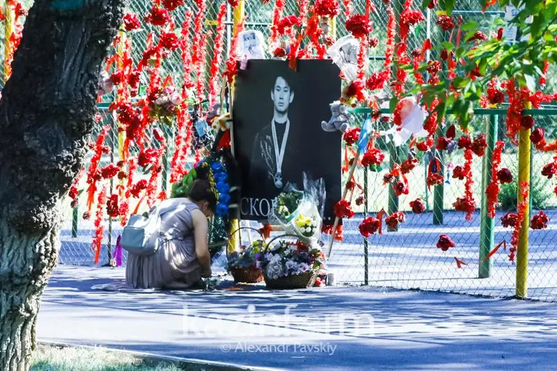 Almatylyqtar Denıs Tenniń eskertkishine gúl shoqtaryn qoıyp jatyr