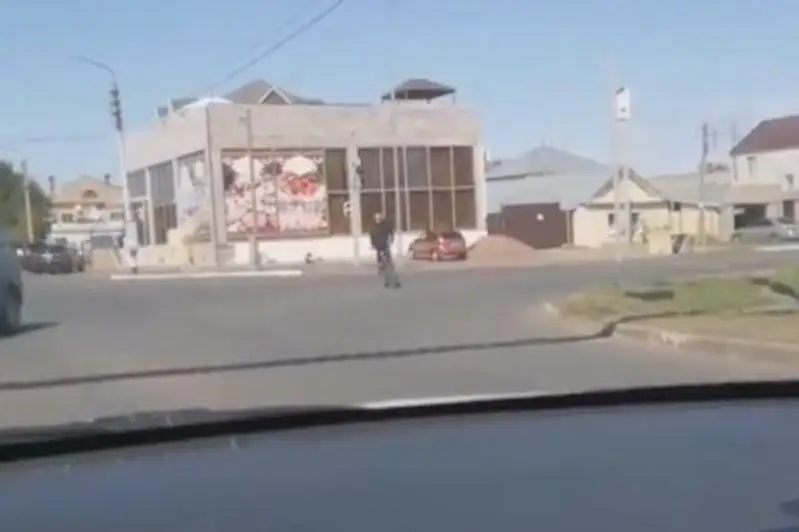 Oralda turǵyn velosıpedti teris otyryp, aıdaǵan