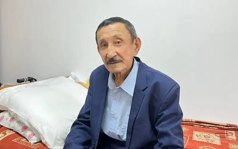 Парта үстіндегі кеңседе аққұбаны сиқыту