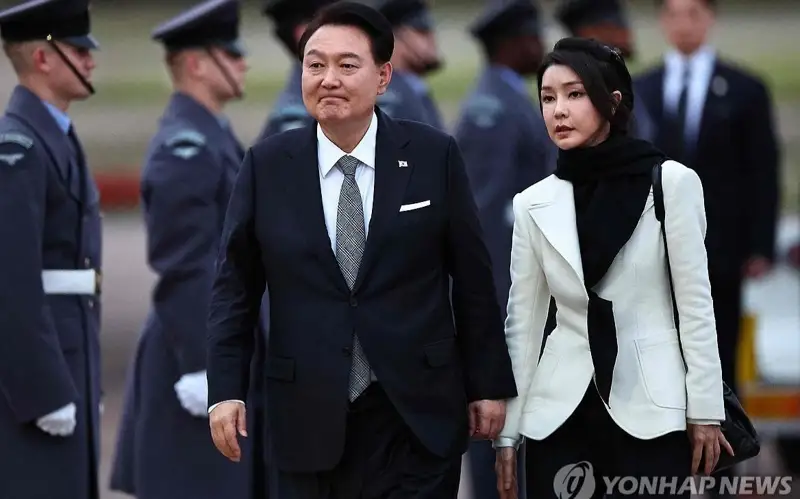 当地时间11月20日，韩国总统尹锡悦（左）和夫人金建希飞抵伦敦斯坦斯特德机场