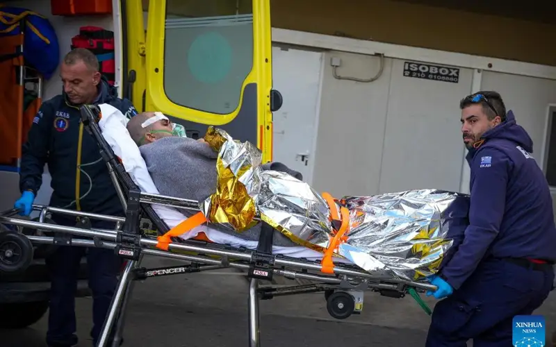 Rescuers transfer a rescued sailor to an ambulance on the Aegean Sea island of Lesvos, Greece, Nov. 26, 2023 