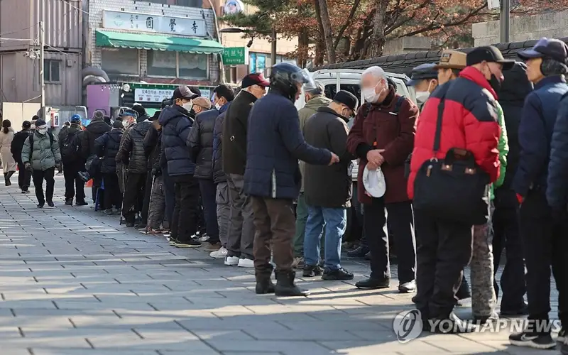 Seniors line up to receive a free lunch in Jongno Ward in Seoul on Jan. 1, 2024