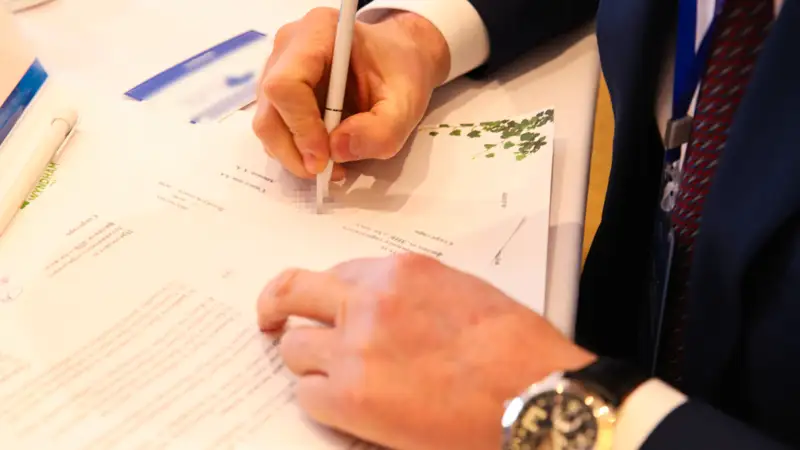 Человек пишет Адам жазады ручка қалам конференция