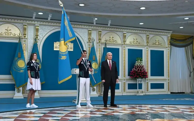 President Tokayev hands in state flag to 2024 Olympic Games participants.