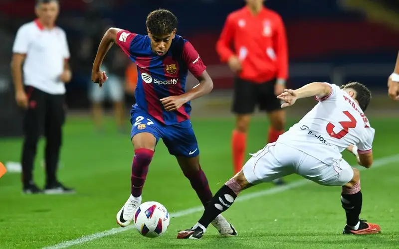   Lamine Yamal (L) vies with Adria Pedrosa of Sevilla FC during a La Liga football match, Sept. 29, 2023