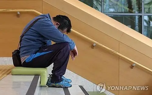 This undated file photo shows an apparently despair-stricken patient sitting on the steps of a hospital