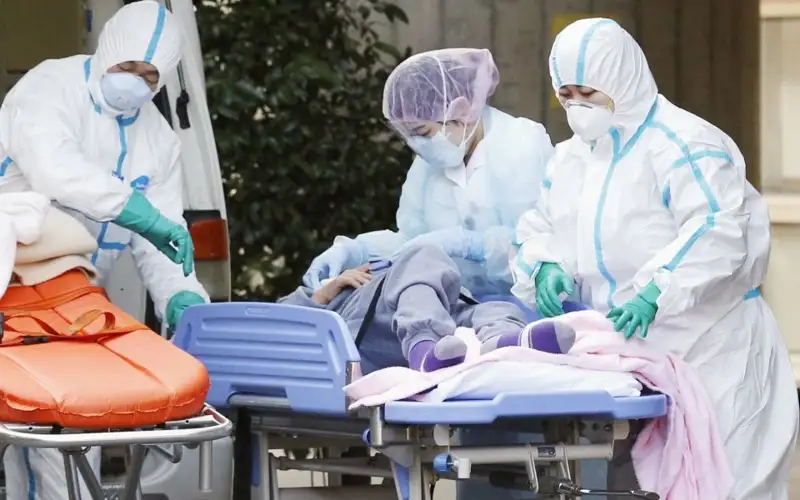 File photo taken in February 2022 shows medical personnel transporting a COVID-19 patient to the Center Hospital of the National Center for Global Health and Medicine in Tokyo. 