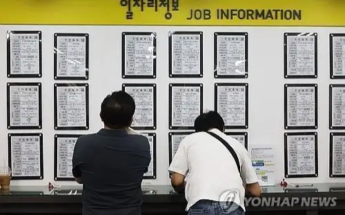 This Sept. 11, 2024, file photo shows jobseekers checking job postings at an employment center in Seoul.