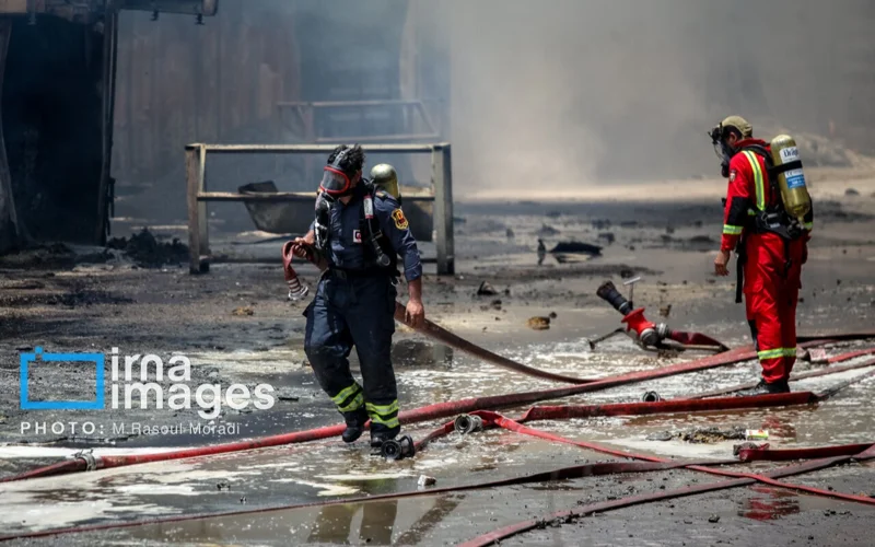 Firefighters trying to extinguish fire caused by an explosion at Shahid Rajaee Port in southern Iran