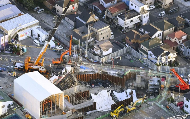 Photo taken from a Kyodo News helicopter shows a large sinkhole at an intersection in Yashio in Saitama Prefecture, near Tokyo, on May 1, 2025, which swallowed a truck and its driver.