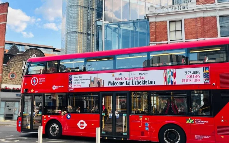Double-decker buses with bright “Welcome to Uzbekistan” banners have appeared on the streets of London.