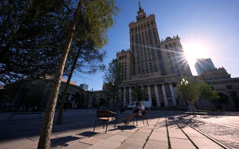 A man sits at a square next to the Palace of Culture and Science in Warsaw, Poland, on July 1, 2025. Poland's meteorological authorities have issued heat warnings for much of the country this week. 