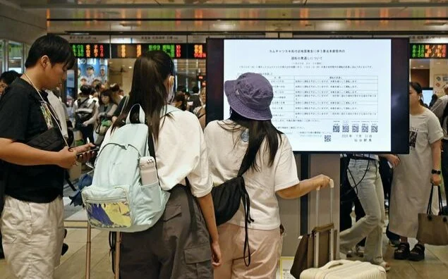 Travelers check train service information at JR Sendai Station in Sendai on July 31, 2025.