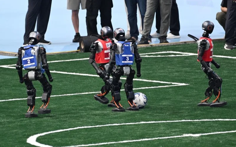 Humanoid robots play football during the opening ceremony of The 2025 World Humanoid Robot Games in Beijing, capital of China, Aug. 14, 2025. 