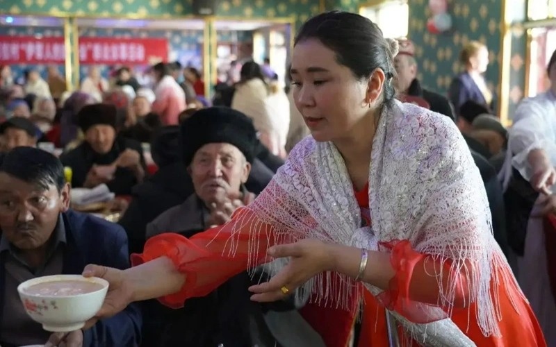 Как казахи отмечают Наурыз в Китае Девушка раздает угощения в Китае